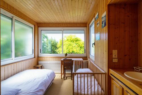 ein Schlafzimmer mit einem Bett und einem Waschbecken in einem Zimmer in der Unterkunft Le Huic - Maison pour 9 avec jardin proche plage in Bénodet