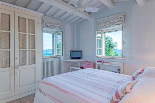 een witte slaapkamer met een bed en 2 ramen bij PODERE SAN GIORGIO 6, Emma Villas in Manciano