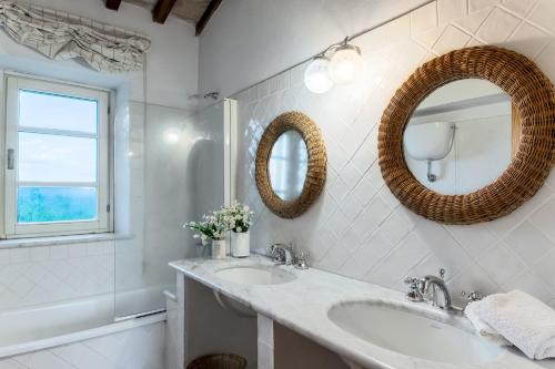een badkamer met 2 wastafels en een spiegel bij PODERE SAN GIORGIO 6, Emma Villas in Manciano