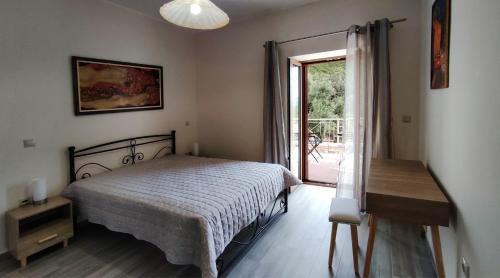 a bedroom with a bed and a sliding glass door at Olive Stonehouses - Alkistis in Kalamata