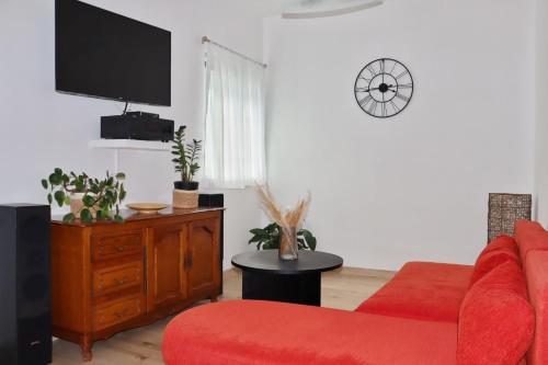 sala de estar con sofá rojo y TV en Apartment Elena, en Sumartin