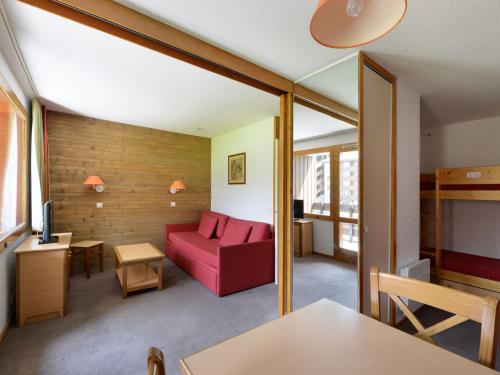 - un salon avec un canapé rouge dans l'établissement Studio divisible au pied des pistes avec balcon et casier à skis - FR-1-181-2083, à La Plagne Tarentaise