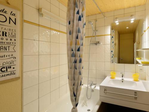 bagno con lavandino, vasca e specchio di Studio Belle Plagne, 1 pièce, 4 personnes - FR-1-181-2059 a La Plagne Tarentaise