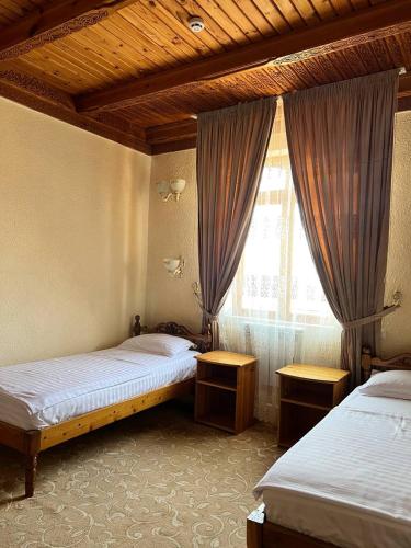 a bedroom with two beds and a window at Hotel Caravan Serail in Samarkand