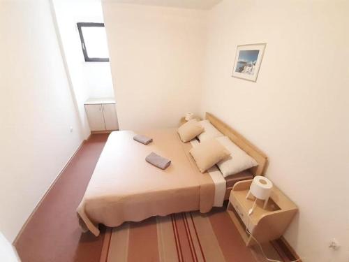 a small bedroom with a bed in a room at APARTMANI DELAS in Pješčana Uvala