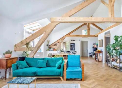 un salon avec un canapé bleu et des chaises dans l'établissement Loft Veyrier, à Veyrier-du-Lac