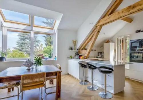 - une cuisine avec une table et des tabourets en bois dans l'établissement Loft Veyrier, à Veyrier-du-Lac