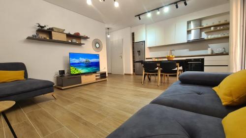 a living room with a couch and a tv and a table at Shiny San Pietro Apartment in Mullini i Danit