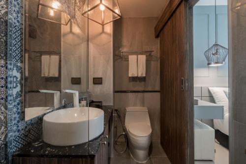a bathroom with a sink and a toilet at Palmyrah Surin Beach Residence in Surin Beach