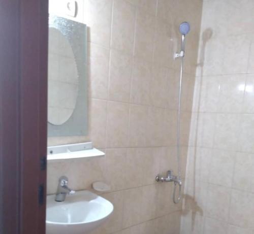 a bathroom with a sink and a shower with a mirror at THE PILLAR MOTEL in Kigali