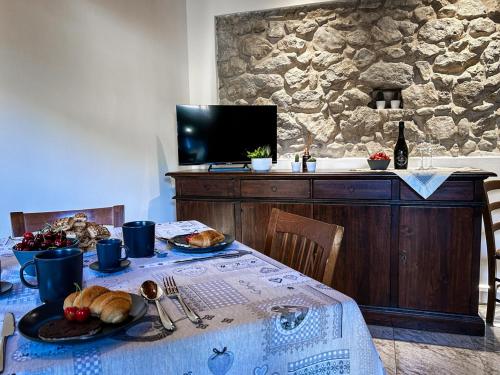 une table avec une assiette de pain et une télévision dans l'établissement Il Vicoletto, à Marostica