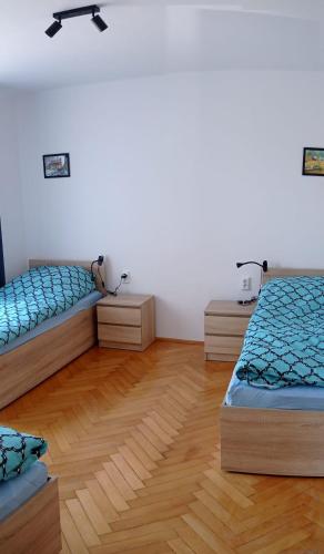 a room with three beds and a wooden floor at Hostel Wiśniowa 55 in Wrocław