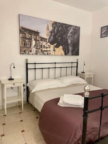 a bedroom with a bed and a painting on the wall at Appartamento San Niccoló GR in Florence