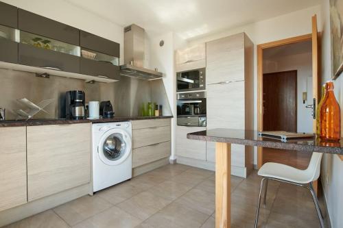 une cuisine avec une machine à laver et un lave-linge dans l'établissement Appartement Isula F2 vue mer Sanguinaires, à Ajaccio