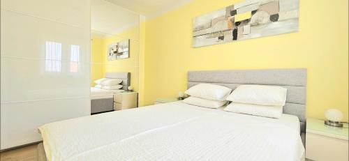 a bedroom with a white bed with white pillows at apartments oaza, vrsi mulo in Vrsi