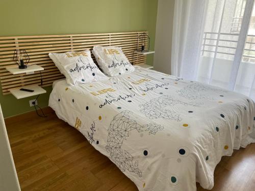 - une chambre avec un grand lit et une couette blanche dans l'établissement Élégant logement avec vue sur l'océan, à La Baule