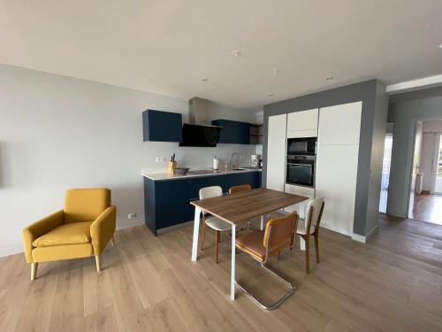 une cuisine et une salle à manger avec une table et des chaises dans l'établissement Élégant logement avec vue sur l'océan, à La Baule