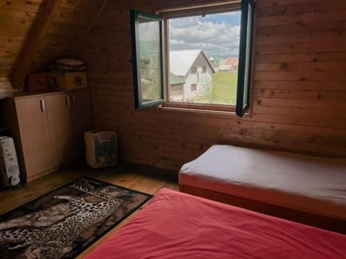 Habitación con cama y ventana en una cabaña de madera en Anja rent house en Žabljak
