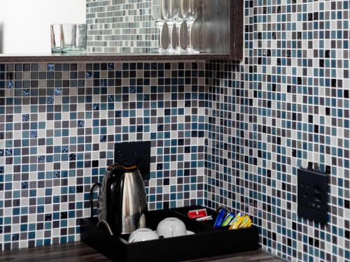 encimera de cocina con paredes de azulejos azules y fregadero en Royal Lodge, en Sibasa