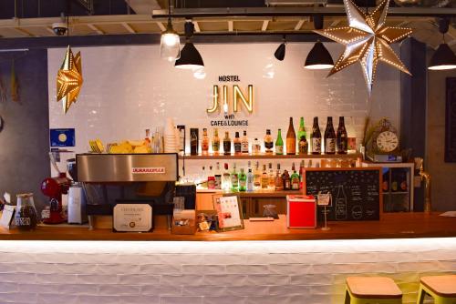 a bar in a restaurant with a counter with alcohol at Hostel JIN in Osaka