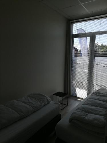a bedroom with two beds and a large window at Nuvola ULTIMO Resort in Zottegem