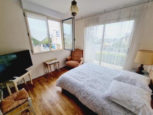 a bedroom with a bed and a flat screen tv at Villa les mouettes, au bord de la mer. in Saint Malo