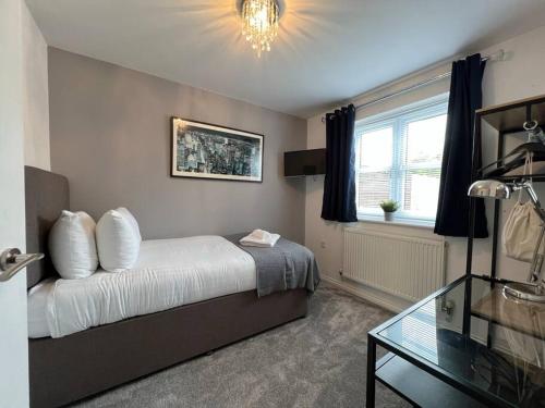 1 dormitorio con cama y mesa de cristal en Three Bed Townhouse with Parking en Telford