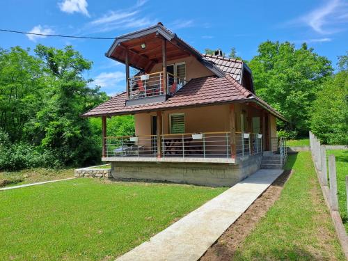 a house with a balcony on top of it at Vikendica Pored Drine in Crvica