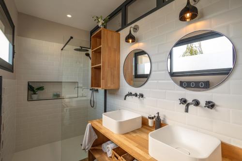 een badkamer met een wastafel en een spiegel bij L'entre deux-suite romantique - jacuzzi privatif in Le Somail