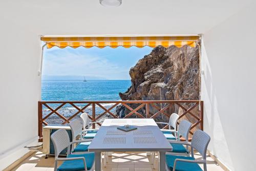 Una mesa y sillas en un balcón con vista al mar. en Duplex Ocean View Apartment in Neptuno, en Puerto de Santiago