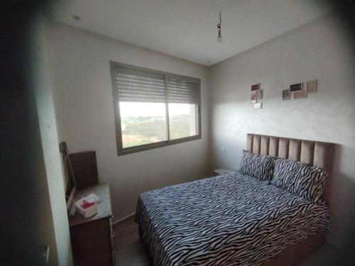 - une chambre avec un lit et une fenêtre dans l'établissement Appartement a louer situé à proximité de la plage 500 m à dahoumy cité bouznika, à Bouznika