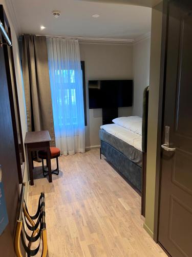 a hotel room with a bed and a table and a chair at Biologen Herdla in Askøy