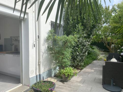 une maison blanche avec une terrasse ornée de plantes dans l'établissement Zénitude et proximité, à Billère