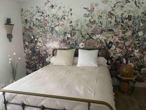 - une chambre avec un lit et un papier peint floral dans l'établissement Zénitude et proximité, à Billère