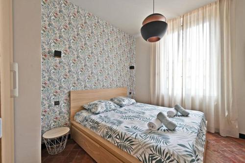 a bedroom with a bed in a room with a wall at Le Saint-Laurent - Parking Gratuit - Terrasse - Wi-Fi in Avignon