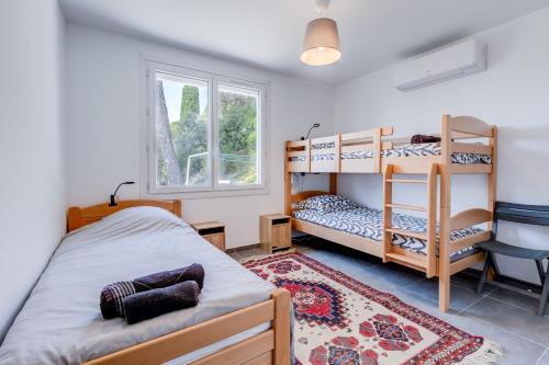 - une chambre avec 2 lits superposés et un tapis dans l'établissement Villa Les Cigales Velaux, à Velaux