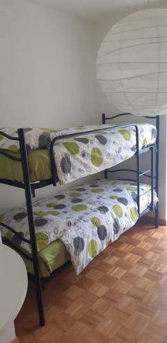 a bunk bed with a comforter on top of it at Easy Gardalake in Riva del Garda