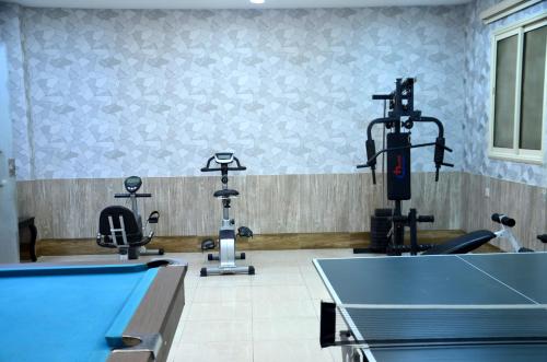 a gym with a pool table and two exercise machines at فندق فربيون ابها - Ferbion Hotel Abha in Abha