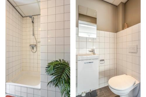 a bathroom with a toilet and a tub and a sink at Enschede83 in Enschede
