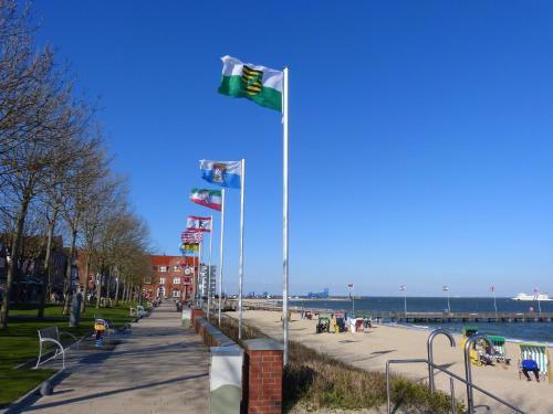 een rij vlaggen op een paal naast een strand bij Haus in der Innenstadt 'Gröde', Große Straße in Wyk auf Föhr