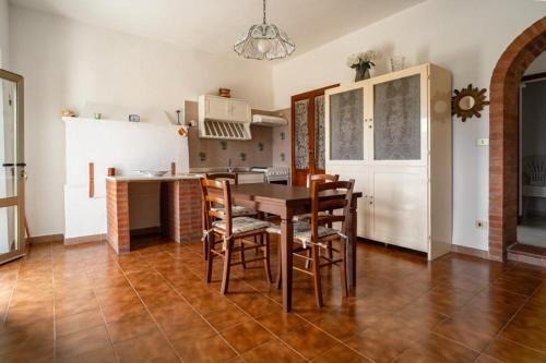 uma cozinha e sala de jantar com mesa e cadeiras em casa Luciana em Rio nellʼElba