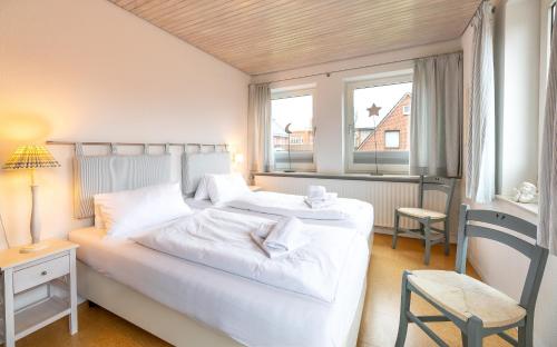 een slaapkamer met 2 witte bedden en een raam bij Haus in der Innenstadt 'Sylt', Große Straße in Wyk auf Föhr