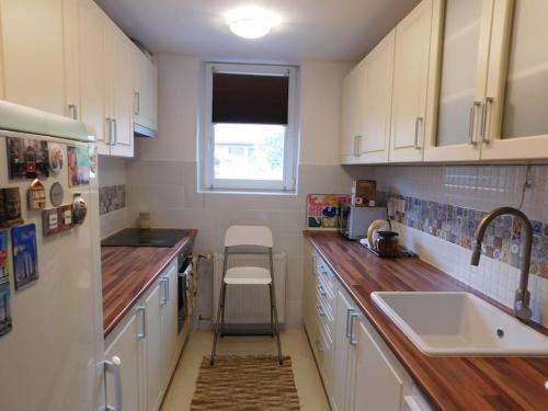 a kitchen with white cabinets and a sink and a window at Family house by the Sziget festival in Budapest