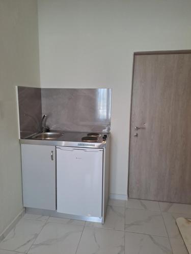 a small kitchen with a sink and a refrigerator at Golden Beach-Tsianis Apartments in Nea Mesangala