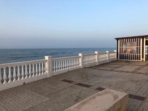 a white railing on a boardwalk next to the ocean at RIBERA PLAYA ALHAMAR in Sitio de Calahonda
