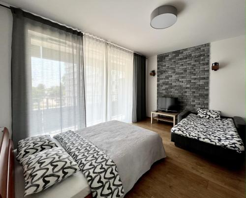 ワルシャワにあるK22 Sky Apartments in the Warsawのベッドルーム1室(ベッド1台、大きな窓付)