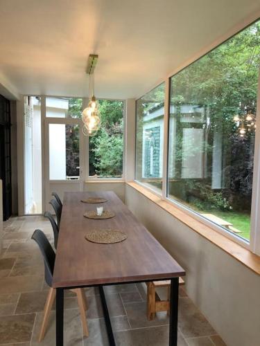 d'une salle à manger avec une table et quelques fenêtres. dans l'établissement La Ninette du Domaine de Maubuisson, à Ver-sur-Mer