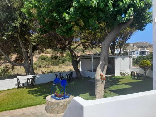 a view of a yard with a tree and chairs at RESTIA in Agios Petros