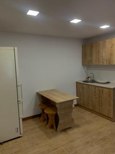 Una cocina con una mesa de madera y un refrigerador. en Best Sevan Villa 2, en Sevan