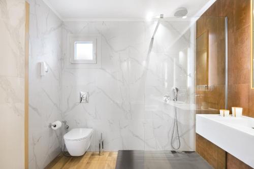 a white bathroom with a shower and a sink at Alexandra Elegance Bridging Generations in Potos